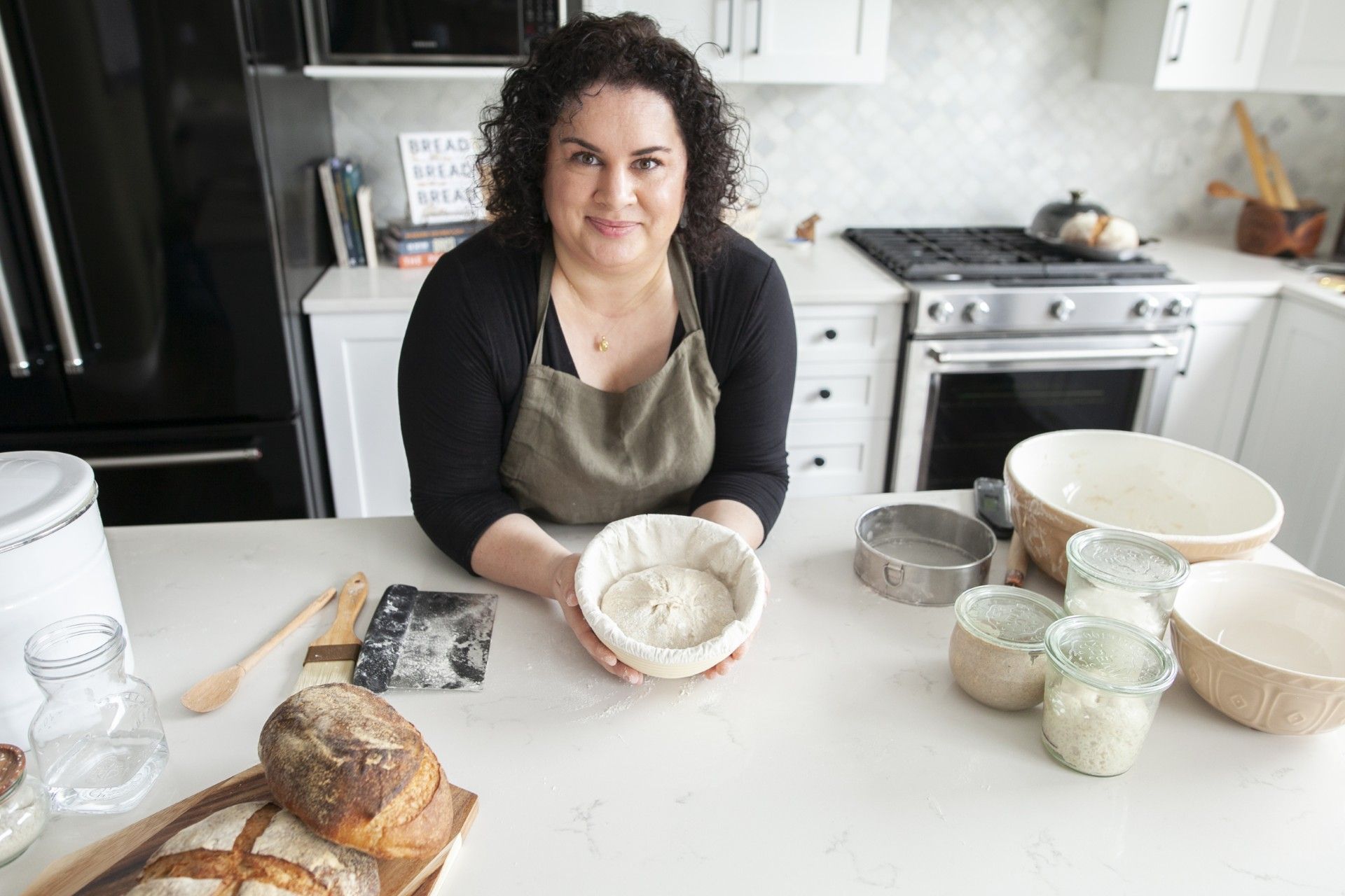 Claire in her kitchen with a banneton of dough